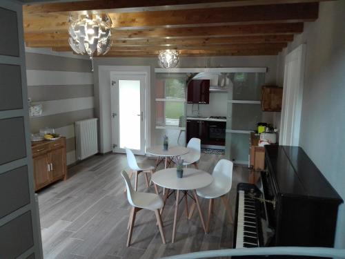 a kitchen with two tables and white chairs and a piano at eden in Cannobio