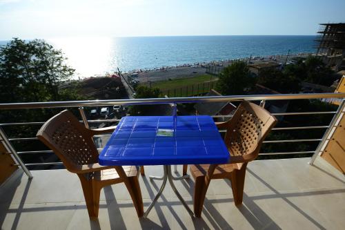 a blue table on a balcony with a view of the beach at Medea Kvariati in Kvariati