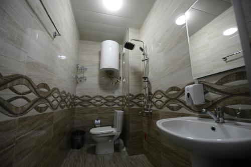 a bathroom with a sink and a toilet and a mirror at Medea Kvariati in Kvariati