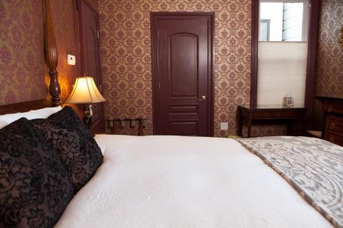 a bedroom with a white bed and a door at Monte Cristo Bed and Breakfast in San Francisco