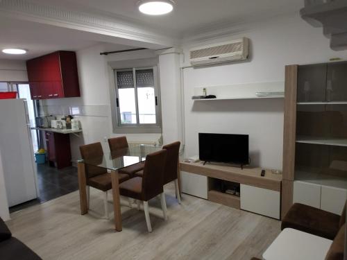 cocina y comedor con mesa y TV en apartamento Miñes en Zaragoza