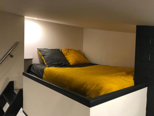 アラスにある52 Grand placeのベッドルーム1室(黄色い毛布付きのベッド1台付)