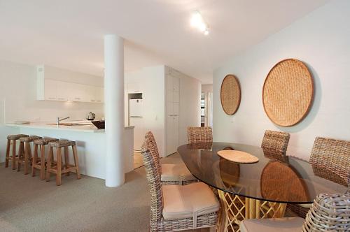a kitchen and dining room with a glass table and chairs at Naousa II in Noosa Heads