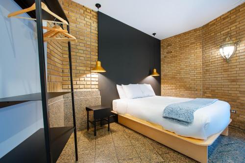 um quarto com uma cama e uma parede de tijolos em Les Lofts de la Gare - Par Les Lofts Vieux-Québec em Cidade de Quebec