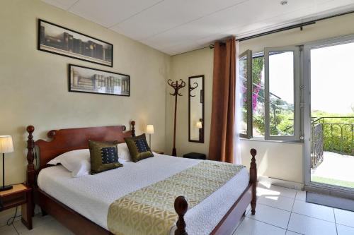 a bedroom with a bed and a large window at Le Panoramic Boutique Hôtel in Nice