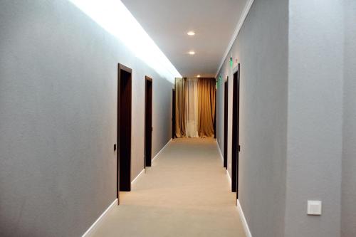 a hallway with black doors and white walls at Hotel Roberto Slanic Prahova in Slănic
