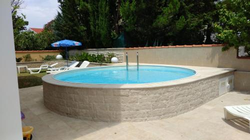 a large swimming pool in a stone wall at Apartments Jadera in Privlaka