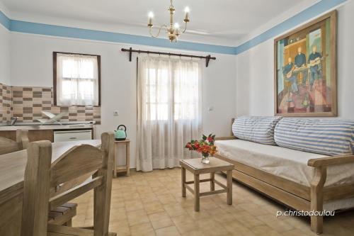 a living room with a couch and a kitchen at Philoxenia Apartments in Karpathos