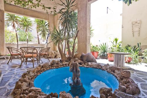 a pool in the middle of a patio with a bear fountain at Philoxenia Apartments in Karpathos