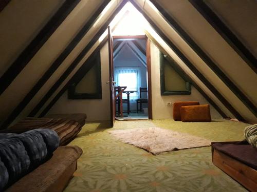 a attic room with a bed and a window at Vikend kuća Elmina Gorani VISOKO in Visoko