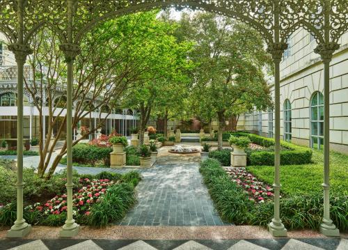 a garden with red and white flowers and trees at Hotel Crescent Court in Dallas