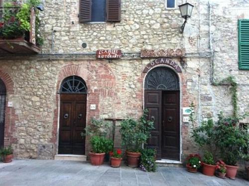 a stone building with two doors and potted plants at Locanda il Cacciatore in Pari