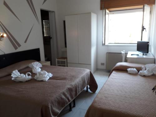a hotel room with two beds with towels on them at Hotel Santa Caterina in Gizzeria