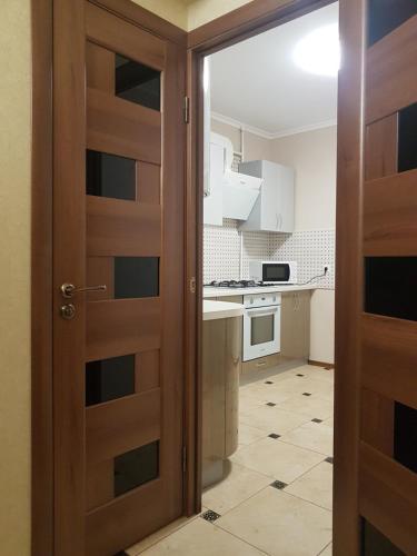 a door leading to a kitchen with white cabinets at 43 Квартира in Bila Tserkva