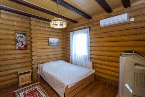 a bedroom with a bed in a log cabin at Gostynnyi dim Zatyshok in Dyyda