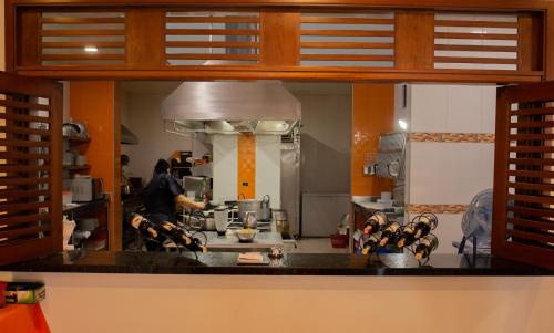 a kitchen with a person preparing food in a kitchen at Hotel Abadias De Zapatoca in Zapatoca