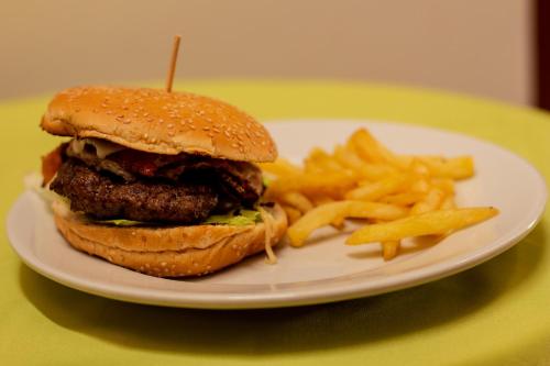a plate with a hamburger and french fries on a table at Hotel Abadias De Zapatoca in Zapatoca
