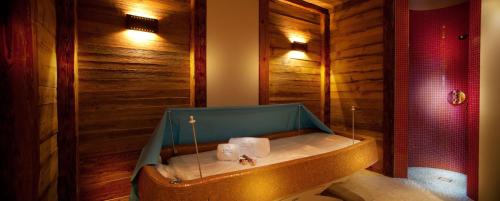 a bathroom with a bath tub with wooden walls at Campiglio Bellavista in Madonna di Campiglio