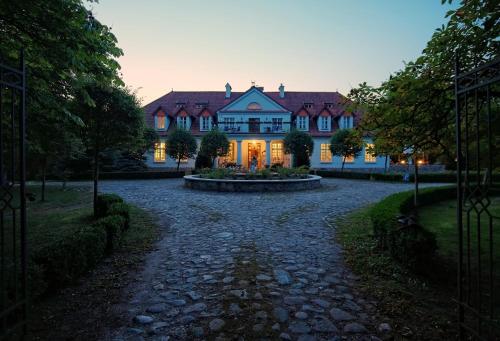 a large house with a driveway in front of it at Dwór w Bychowie in Bychowo