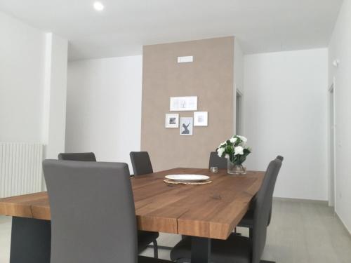 a dining room with a wooden table and chairs at Ledwars in Taviano