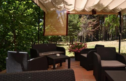 a patio with chairs and a table and trees at Hospedium Hostal Almanzor in Navarredonda de Gredos
