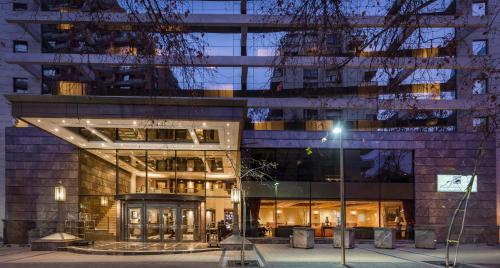 a large building with a lit up facade at night at Plaza El Bosque Ebro in Santiago