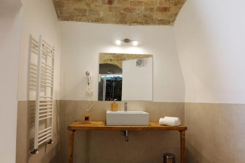 マテーラにあるL' Abbraccio dei Sassiのバスルーム(洗面台、鏡付)