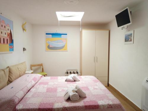 a bedroom with a pink bed with towels on it at B&B Celestina Ischia in Ischia