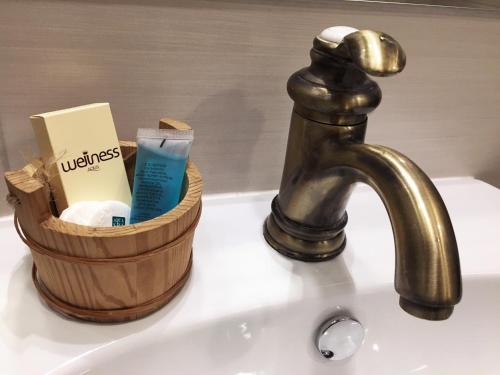 a sink with a faucet and a basket of toiletries at Apartment Auer_Belgrade in Belgrade
