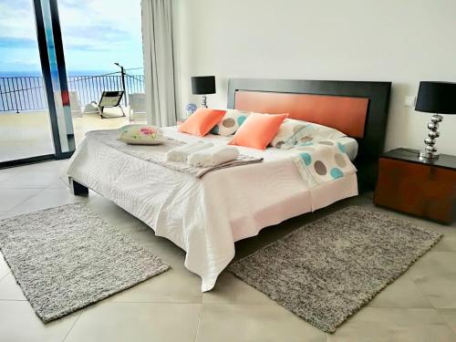 a bedroom with a large bed and a balcony at Moradia Syso in Arco da Calheta