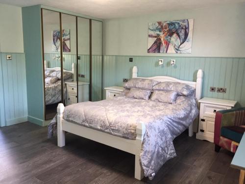 a bedroom with a bed and a large mirror at Mill Cottages in Kesh