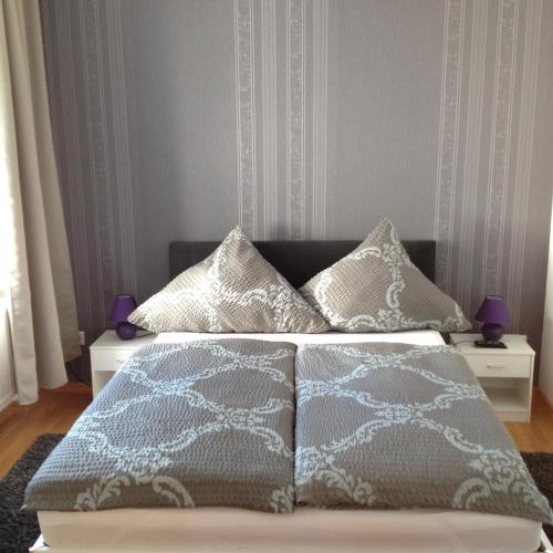 a bedroom with a bed with white and gray blankets and pillows at Ferienwohnung am Schlossparkcenter in Schwerin