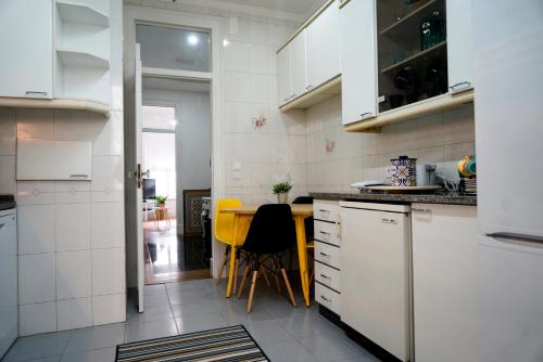 a kitchen with white cabinets and a yellow table at Almirante GuestHouse in Lisbon