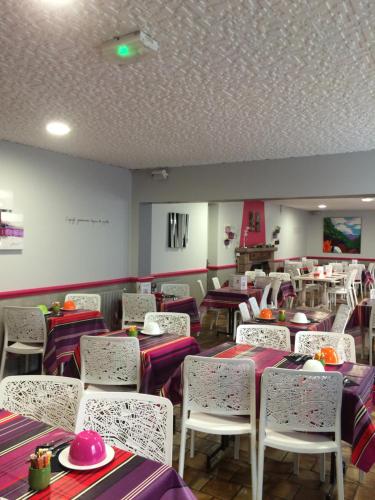 a dining room with purple and white tables and chairs at Hôtel Juantorena in Saint-Étienne-de-Baïgorry