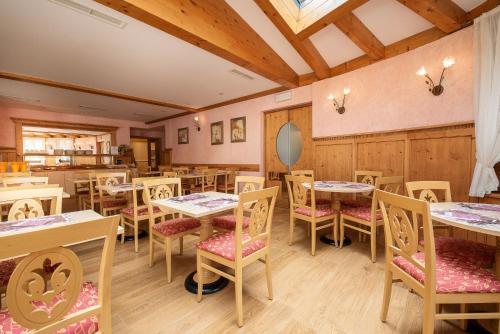 Hotel Belvedere في سان مارتينو دي كاستروزا: مطعم به طاولات وكراسي في غرفة