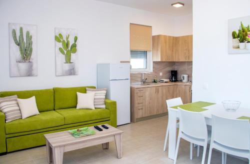 a living room with a green couch and a table at Gennadi Gardens exclusive apartments in Gennadi
