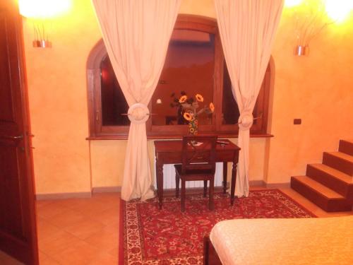 a room with a table and a window with a vase of flowers at Agriturismo Casal Grande in Canepina