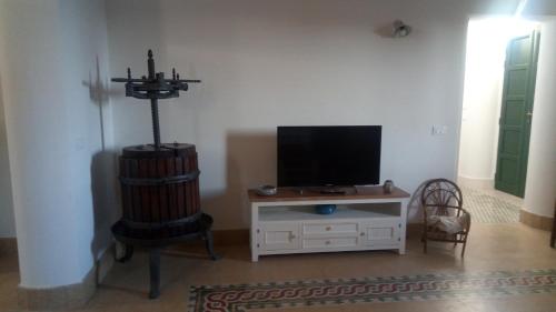 a living room with a tv and a stand with a television at La Noria in Marsala