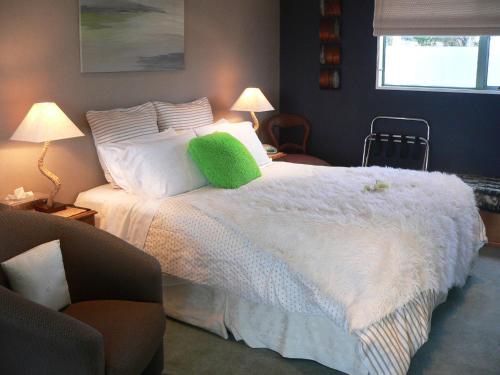 a bedroom with a bed with a green pillow on it at Molyneux House in Kaka Point