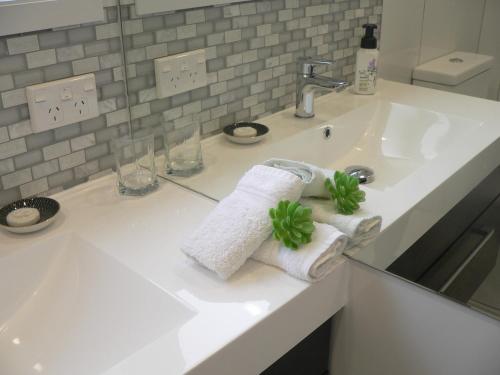 a bathroom sink with two towels and a faucet at Molyneux House in Kaka Point