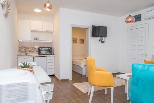 a kitchen and living room with a table and chairs at Apartments Tina in Utjeha