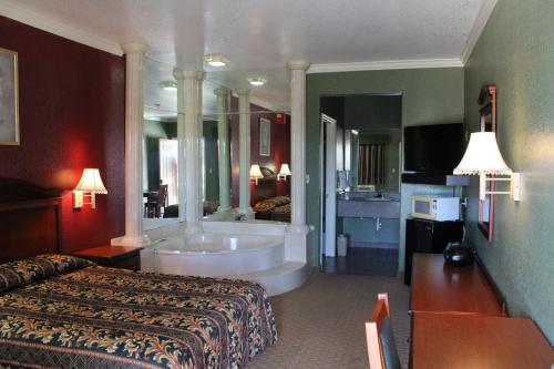 a hotel room with a bed and a bath tub at Budget Inn Pasadena in Pasadena