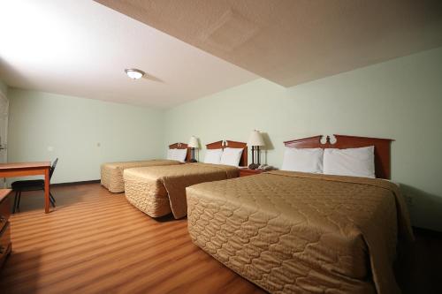 a hotel room with two beds and a desk at Texas Inn Waxahachie in Waxahachie