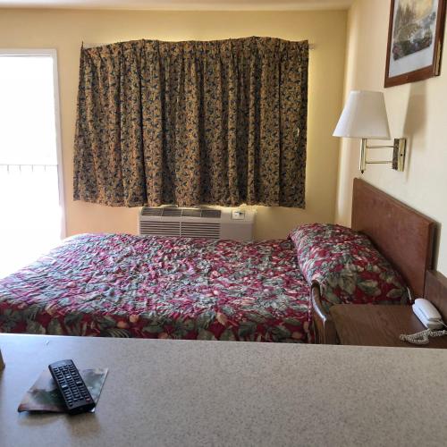 a hotel room with a bed and a window at Country Host Inn in Texarkana