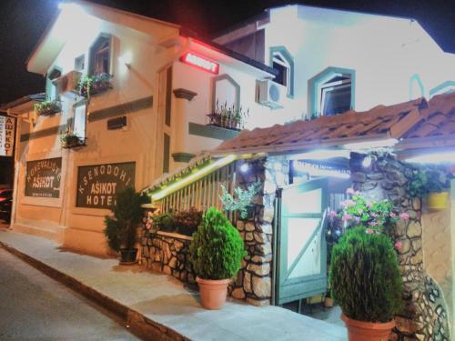a building with a door and potted plants in front of it at Hotel Asikot in Gevgelija