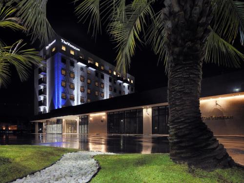 a building with a palm tree in front of it at Venezian Hotel Shiroishi Zao in Shiroishi