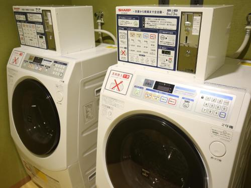 a washing machine and a dryer sitting next to each other at Venezian Hotel Shiroishi Zao in Shiroishi