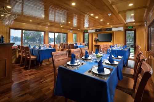 un comedor con mesas y sillas azules en Venezia Cruises, en Ha Long