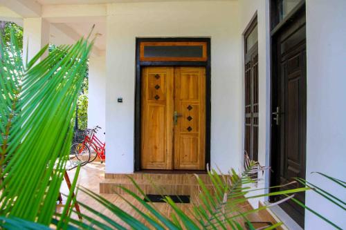 a wooden door on a house with green plants at Miracle Home Stay in Dambulla