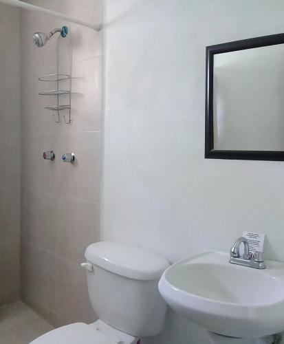 a bathroom with a toilet and a sink and a mirror at Posada San Cristobal in Cuernavaca